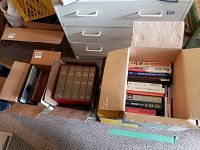 Overview of four boxes with assorted books on floor