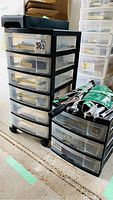Roller carts with transparent drawers holding miscellaneous small parts, cables, and electronics