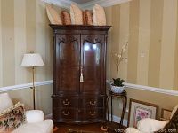 Front view of closed armoire with five pillows on top