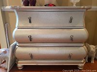 Front view showing all three drawers, silver textured finish, and drop pull handles.