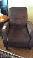 Brown upholstered reclining chair with cushioned armrests and back, shown from front.