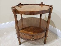 Full view of the two-tier round side table showing the drawer and wooden legs.