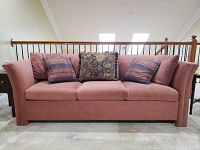 Front view of Sealy sofa bed with seat cushions and decorative pillows showing fabric color and style.