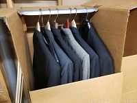 Six assorted men's suit jackets in cardboard storage box