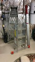 Three ladders positioned in a basement setting: Krause MultiMatic step ladder, aluminum step ladder, and telescoping ladder