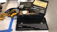 Hole depth micrometer set including dial indicator and multiple rods in black case.