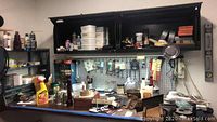 Wide view of workspace with shelves, pegboard, assorted tools, and containers