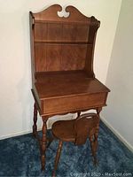 Front view of wooden secretary desk with attached shelves and wooden chair