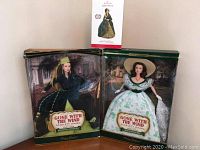 Two boxed Scarlett O'Hara dolls and one Hallmark ornament arranged together