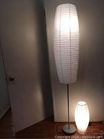 View showing both floor and table lamps illuminated, displaying paper shades and proportions