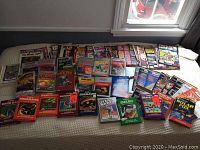 Spread of game boxes and magazines on bed under window light