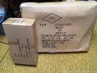 Photo of two sealed cardboard boxes on floor, labeled as Amish Country Wagon and Metal Arched Trellis/Gate.