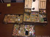 Open top view showing multiple velvet-lined compartments filled with assorted jewelry and hinged mirror