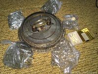 Overhead view of chandelier frame and sealed bags of crystal prisms on carpet