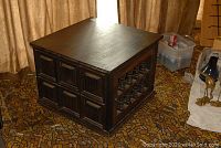 Full view of the mahogany finish wooden side table with paneled sides and turned spindle detailing.