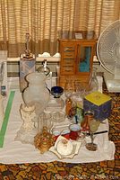 Wide view of all assorted decorative items including jewelry cabinet, glass vases, candle holders, and kitchenware