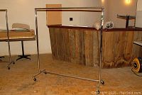 Full view of the metal rolling clothing rack showing frame and wheels.