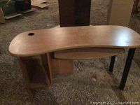 Full view of kidney-shaped melamine desk showing pull-out keyboard tray and shelving.