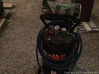 Front and top views of the Pro Air II air compressor showing controls, hose, and brand label.