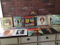 Overview of vinyl records including Anne Murray Greatest Hits, ABBA, Fleetwood Mac, and others arranged on a dresser.