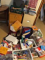 Wide view of office supplies showing DVD packs, coin sorter box, binders, papers and baskets with various stationary items and tools.