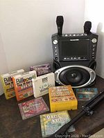 Full lot view showing karaoke unit, microphones, disc sets and tripod stand