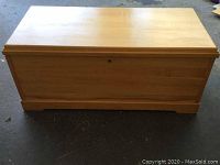 Front view of wooden chest showing the keyhole lock and base detail.