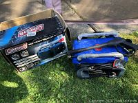Boxed Coleman Pro-Grade Pressure Washer with main unit and handle wrapped in protective film