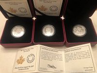Three 2017 Canadian $8 Lion Dance silver coins in red velvet boxes with Certificates of Authenticity shown underneath.