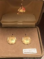 Pair of scalloped clover design earrings displayed in box with 14K gold sticker