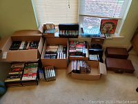 Wide view of the entire collection arranged on the floor by category with cardboard boxes, plastic containers and wooden cases.