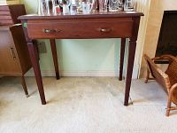 Lightweight wooden desk front view showing single drawer and metal handles.