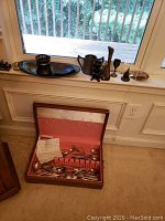 Overview of items on windowsill and box of flatware on floor