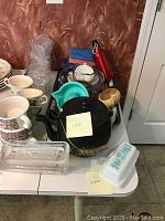 Overview of various kitchen items including ceramic coffee cups, glass bowls, plastic ware, Purex butter dish, and Kookie Kettle with label indicating "KETTLE" and "PYREX"