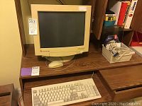 Front view of Gateway 2000 CRT monitor on wooden desk, showing beige yellowed condition.