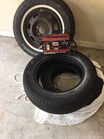16-inch wheel with JR8-15 Lee radial tire, P185-65R15 Integrity tire, and Century battery charger shown together.