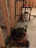 Full view of Yardmaster lawnmower with attached handle, showing red body and wheels.