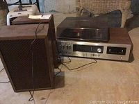 Full view of the stereo system and speakers showing wood casing and dust cover over the turntable.