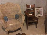 Wicker chair, wooden chair with attached writing desk, and two framed prints against a concrete wall floor background.