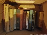 Photo showing a cardboard box with 11 books including 'Management & Organization,' 'Math Without Tears,' and others.