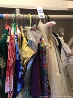 Rack of multiple vintage dresses hung on a closet rod