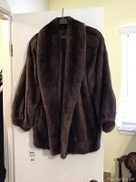 Full front view of brown mink coat hanging on door