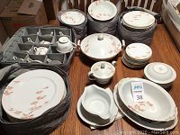 Full view of plates, bowls, cups, saucers, serving pieces with cloth storage bags