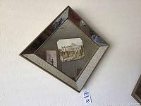 Diamond-shaped mirrored picture frame with two English manor pictures, beveled with distressed mirror effect on edges