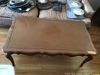 Top view of the rectangular brown coffee table with carved edge details and a smooth surface.