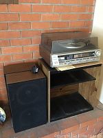 Stereo receiver, speakers, and stand arranged on brick hearth backdrop