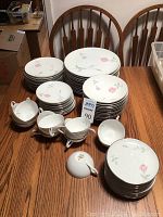 Photo showing the complete set of Sango Japan Fine China dinnerware including plates, cups, saucers, and bowls arranged on wooden table.