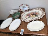 All 6 platters and 1 bowl arranged on table showing front designs and patterns