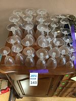 Top view of over 30 vintage crystal goblets showing a variety of stemware arranged on a wooden surface.