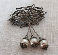 Front view of the vintage silver filigree brooch with three dangling cultured pearls, showing intricate filigree metalwork and pearl details.